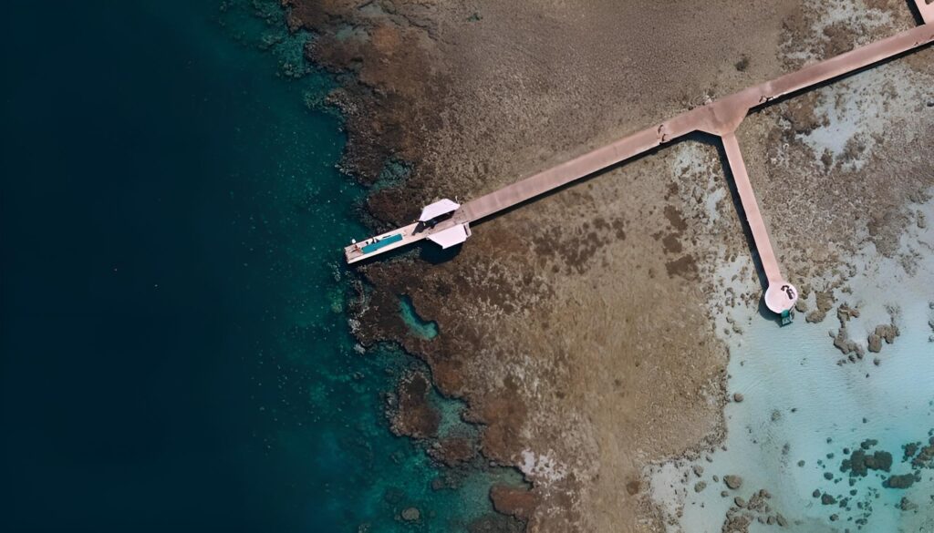 Aerial drone view of the private jetty stretching into the crystal-clear turquoise waters of the Red Sea in Soma Bay.